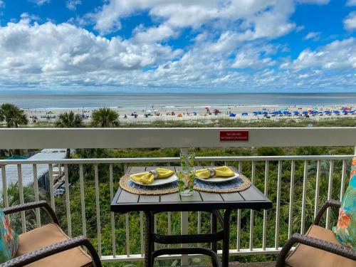 a table on a balcony with a view of the beach at 340 Breakers in Hilton Head Island
