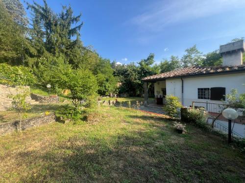 a house with a yard next to a building at La Cascata in Pian di Scò
