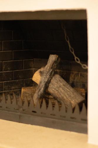 a piece of wood sitting on top of a brick fireplace at La Femme Apartment in Chrysoupolis