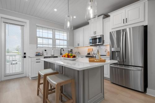 a kitchen with white cabinets and a large island with bar stools at CASA NICA! Luxury Private Pool Home with dock on a saltwater canal! in Bradenton