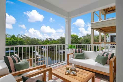a screened in porch with a white couch and chairs at CASA NICA! Luxury Private Pool Home with dock on a saltwater canal! in Bradenton