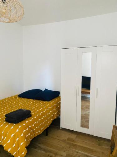 une chambre avec un lit et un miroir dans l'établissement Chambres rénovées proches de Paris Centre, des sites olympiques, avec belle terrasse calme, à Argenteuil