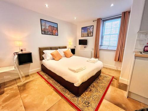 a bedroom with a large bed and a television at The City Pad in Gloucester