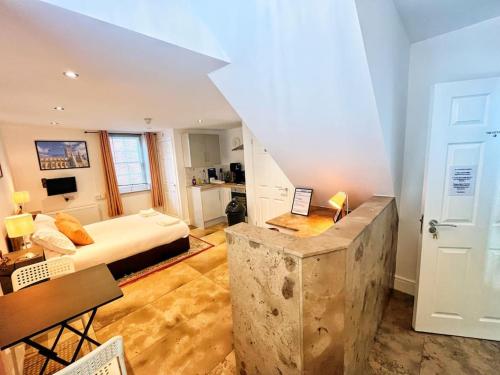 a living room with a bed and a room with a table at The City Pad in Gloucester