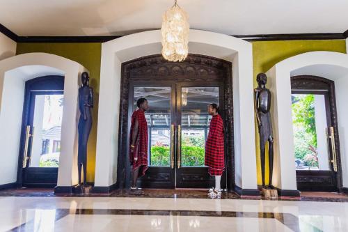 ダル・エス・サラームにあるSea Cliff Hotelの二人の男がドアの前に立っている