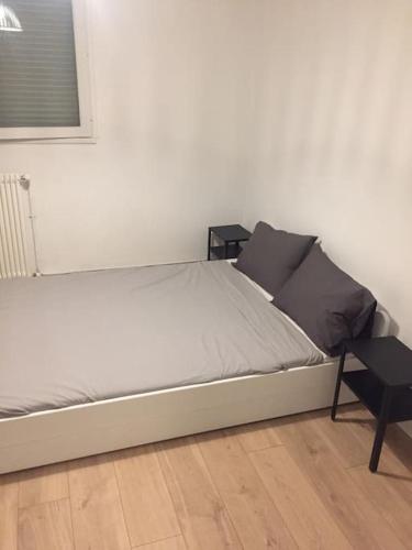 - un lit blanc avec deux oreillers et une table dans l'établissement Appartement Hyper centre - Agen, à Agen