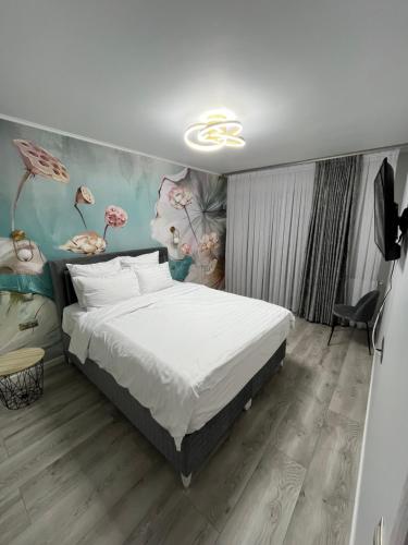 a bedroom with a bed and a painting on the wall at Glam Studios in Sibiu