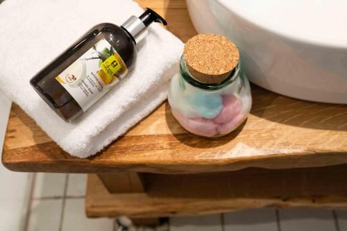 a bottle of soap sitting on a table next to a toilet at Logis Hôtels Gnàc é Pause in Saint-Lon-les-Mines