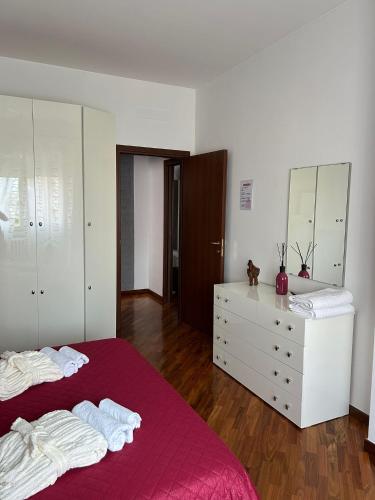 a bedroom with a bed and a dresser with towels at LA CASA DI AMBRA in Limbiate