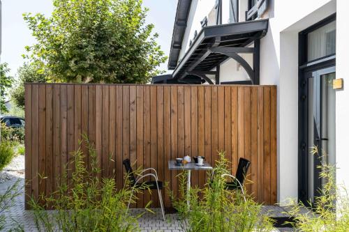 a wooden fence with a table next to a building at Logis Hôtels Gnàc é Pause in Saint-Lon-les-Mines