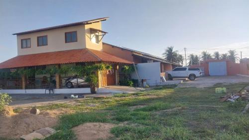 ein Haus mit einem großen Garten davor in der Unterkunft Casa de Praia in Luis Correia