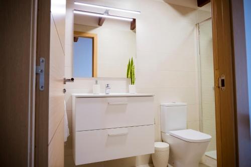 a white bathroom with a toilet and a sink at La Casa de Leo in Garachico