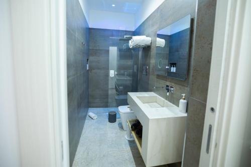 un bagno con lavandino, WC e specchio di I venti Mazara del Vallo a Mazara del Vallo