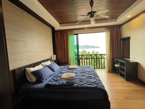 Un dormitorio con una cama con ventilador de techo. en Olumis Nexus Apartment, en Tuaran