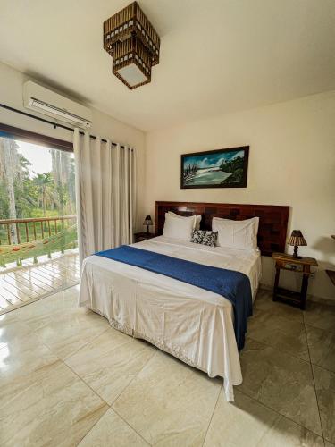 a bedroom with a large bed and a large window at Conchas do Mar Residence in Itacaré