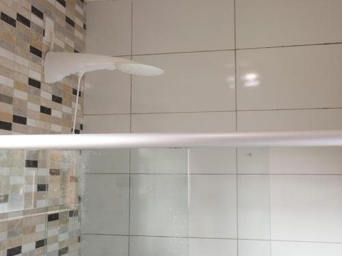 a shower with a shower head in a bathroom at Conchas do Mar Residence in Itacaré