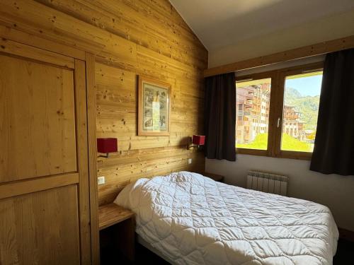 une chambre avec un lit dans une pièce en bois dans l'établissement Résidence Le Centaure - 4 Pièces pour 8 Personnes 581, à Aime La Plagne