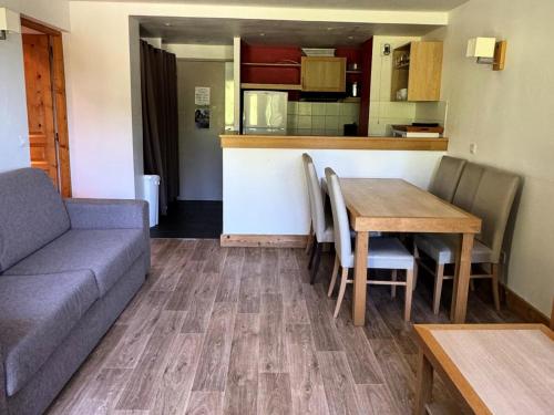 un salon avec un canapé et une table et une cuisine dans l'établissement Résidence Le Centaure - 2 Pièces pour 6 Personnes 621, à Aime La Plagne