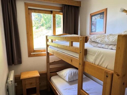 une chambre avec deux lits superposés et une fenêtre dans l'établissement Résidence Le Centaure - 2 Pièces pour 6 Personnes 621, à Aime La Plagne
