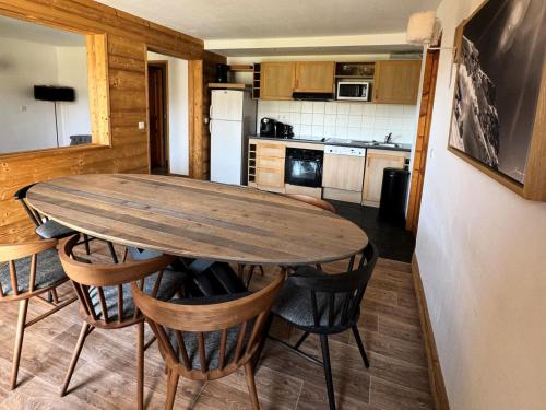 une cuisine avec une table et des chaises en bois dans l'établissement Résidence Le Centaure - 4 Pièces pour 8 Personnes 571, à Aime La Plagne