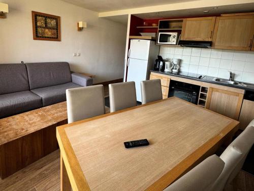 - une cuisine et une salle à manger avec une table et un canapé dans l'établissement Résidence Le Centaure - 3 Pièces pour 6 Personnes 631, à Aime La Plagne