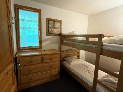 une chambre avec deux lits superposés et une fenêtre dans l'établissement Résidence Le Centaure - 3 Pièces pour 6 Personnes 631, à Aime La Plagne