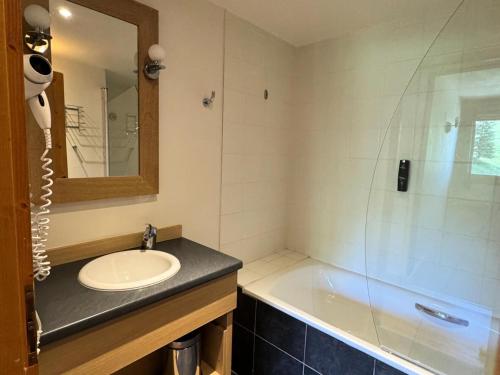 une salle de bain avec un lavabo, une baignoire et un miroir dans l'établissement Résidence Le Centaure - 3 Pièces pour 6 Personnes 651, à Aime La Plagne