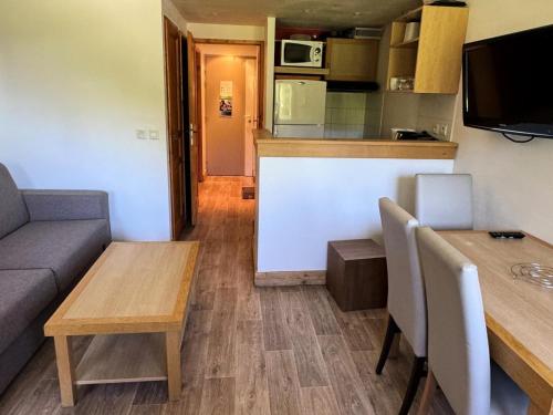 un salon avec un canapé et une table dans l'établissement Résidence Le Centaure - 2 Pièces pour 4 Personnes 701, à Aime La Plagne