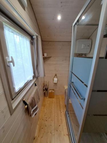 Cette petite chambre dispose d'une fenêtre et d'un miroir. dans l'établissement Magnifique roulotte en plein nature, à Saint-Jean-de-Boiseau