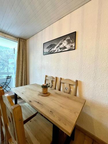 - une table et des chaises en bois dans l'établissement Résidence Le Pastourlet - RESIDENCE LE PASTOURLET-Classé 3 MAE-4531, à Vars