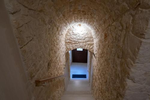 a stone tunnel with a light at the end of it at EvoAntico1900 in Santeramo in Colle