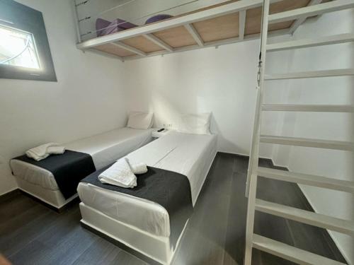 a bedroom with two bunk beds and a ladder at Lilianna Tinos in Tinos