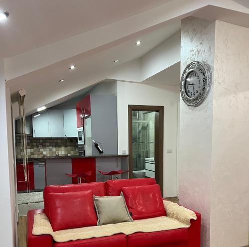 a red couch in a living room with a kitchen at Luxury Apartment in Struga