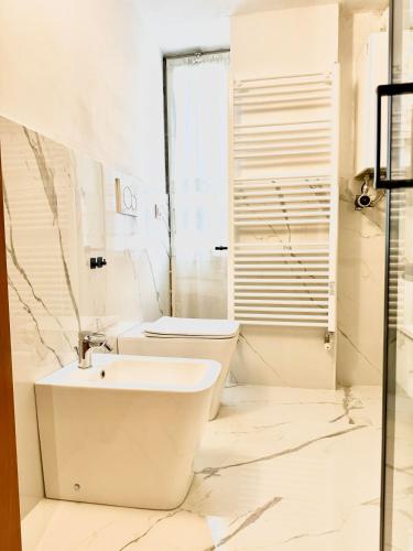 a white bathroom with a sink and a toilet at Milano Brenta Suites Room for 2 in Milan