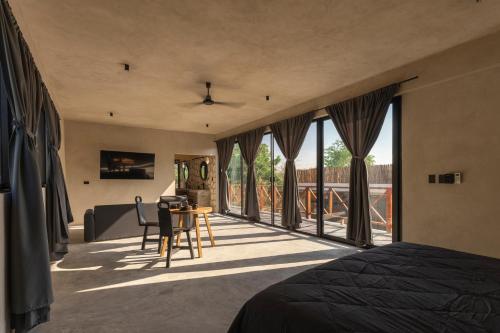 a bedroom with a bed and a table and some windows at Casa Re Valladolid in Valladolid