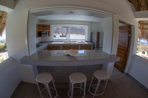 a kitchen with a large island with stools at Casa Pal'mar 17 personas in Bajos de Chila