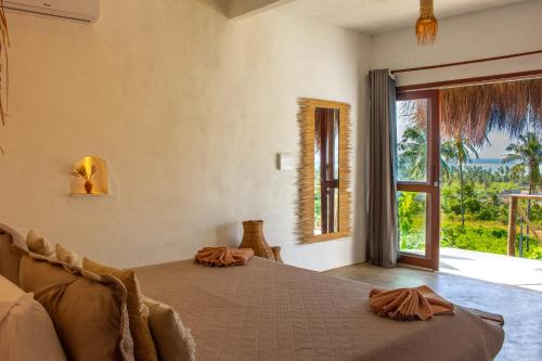 a bedroom with a bed and a large window at Araxá Milagres in São Miguel dos Milagres