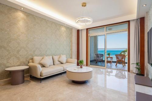a living room with a couch and a table at Sanya Yikehai View Apartments in Sanya