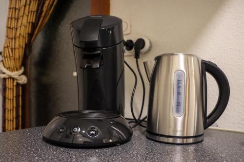 a coffeemaker and a coffee maker on a counter at Tranquil forest chalet by a pond in Veluwe, sleeps 4 in Doornspijk