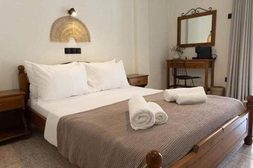 a bedroom with a large bed with towels on it at VASILAS Luxury Rooms & Suites in Agios Georgios