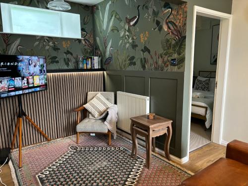 a living room with a chair and a table at The Burrow - 2 bedroom apartment in central Windermere in Windermere