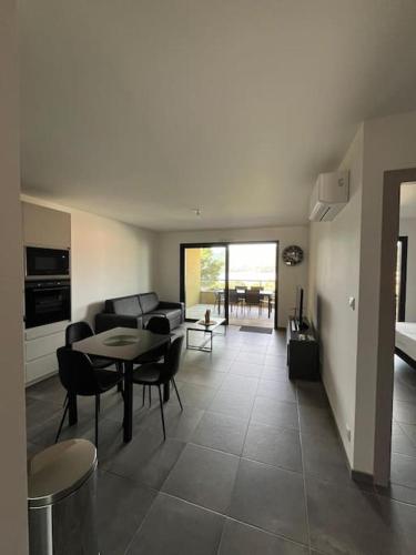 un salon avec un canapé, une table et des chaises dans l'établissement Appartement résidence Bel Orizonte Propriano, à Propriano