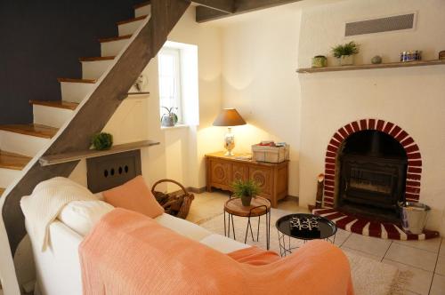 a living room with a couch and a fireplace at Ma petite maison bretonne in Guimiliau