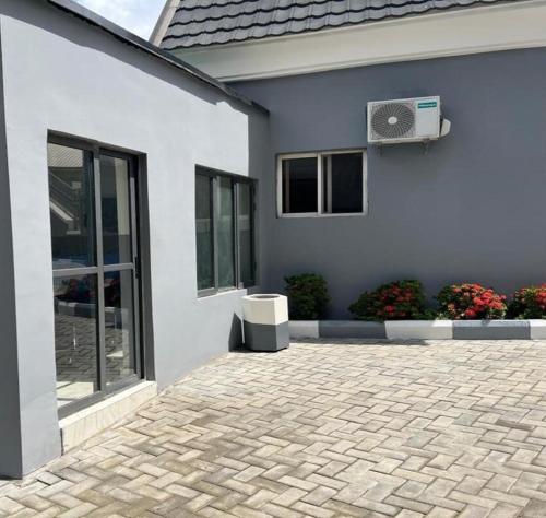 a white house with a fan on the side of it at Kam Apartment and Taverns in Abuja