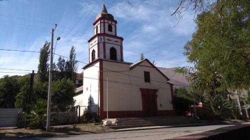 a church with a clock tower on a street at Casaelqui in Vicuña