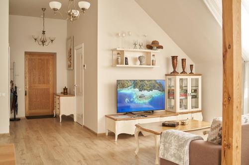 a living room with a tv and a table at Beachfront apartment in Jūrmala