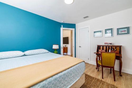 a blue bedroom with a bed and a desk at Florida Gulf Coast Luxury Oasis in St Petersburg