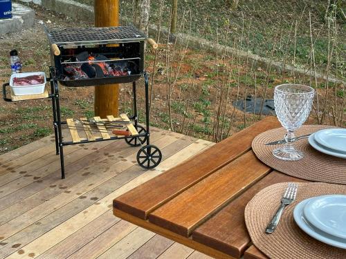 a table with a grill on top of a wooden deck at Cabana com jacuzzi e churrasqueira - Ibiuna SP in Lajeado do Salto