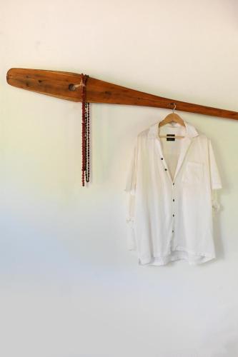 a white shirt on a hanger on a wall at Pousada Habitat Caraíva in Caraíva