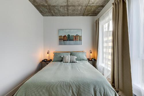a bedroom with a bed and a large window at Le Jules in Quebec City